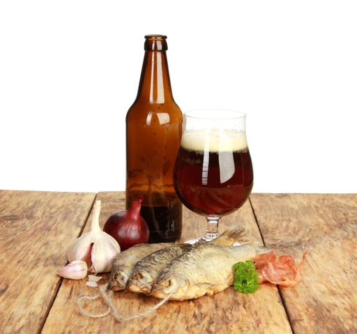 A vertical shot of dried fish in front of the beer