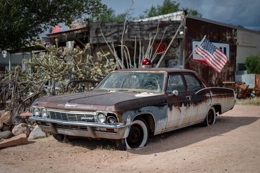 An old Police Sheriff car, fourth generation Chevrolet Biscayne with a red siren on the roof, abandoned