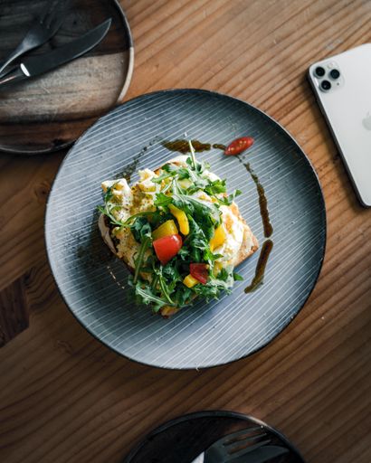 A flat lay shot of a plated breakfast set in a cafe setting