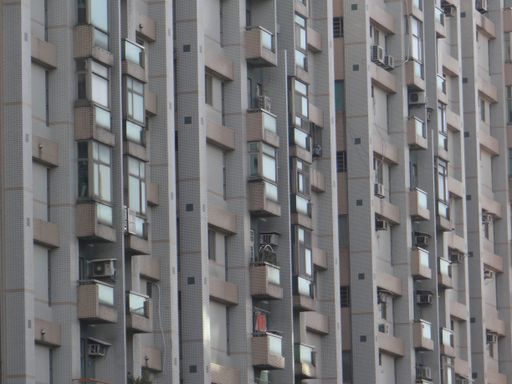 A closeup shot of a gray building with balconies