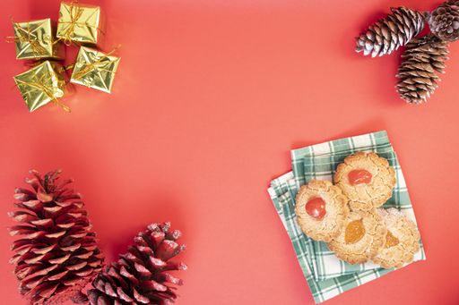 A top view of Christmas background with sweets, small gift boxes and pine cones