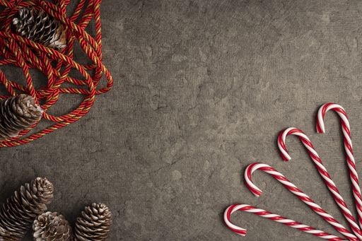 A top view of Christmas background with candy canes and pine cones