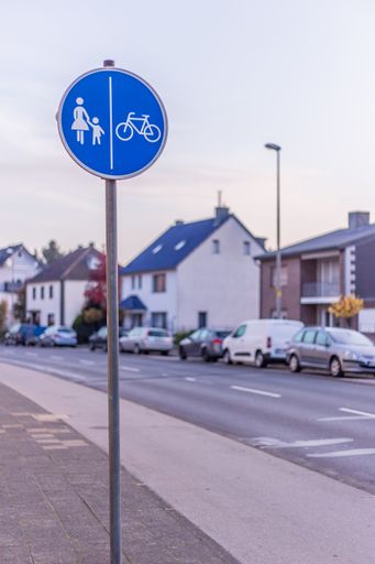 A closeup vertical shot of a pedestrian and bike path sign in a street