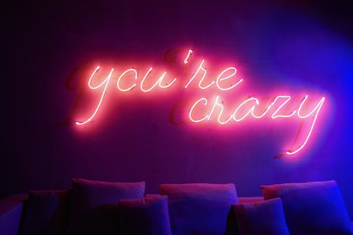 The words "You're Crazy" in neon lights on the wall