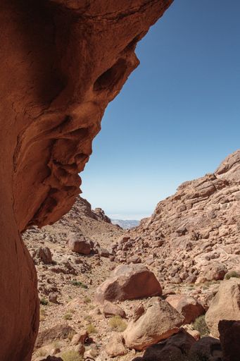 A vertical shot of rocky hills under the sunlight and a blue sky in the countryside