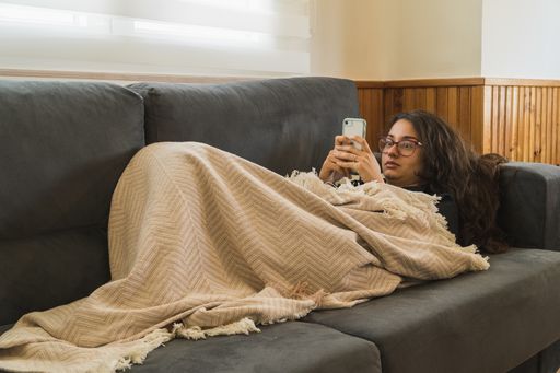 A closeup shot of an attractive female lying on a couch and looking at her phone