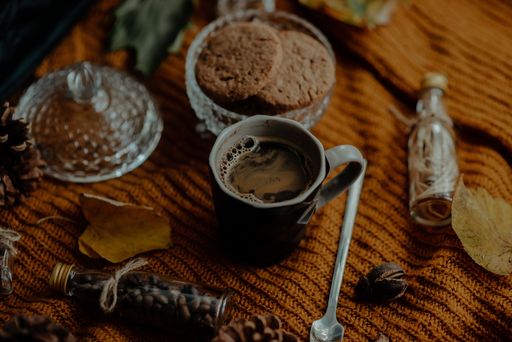 A high angle shot of tasty cookies and coffee in an autumn decoration set