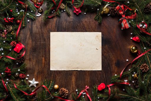 A Christmas background with white paper framed with season decorations