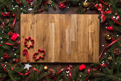 A Christmas wooden board with mini cookie cutters and season decorations