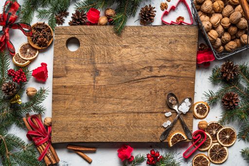 A wooden board with mini cookie cutters and Christmas decorations