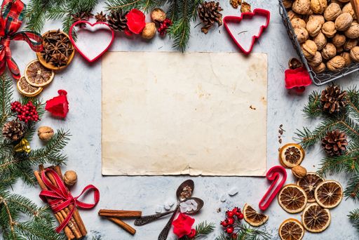 A Christmas background with white paper framed with season decorations