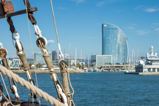 The W Barcelona hotel on blue cloudy sky background seen from a sailing ship