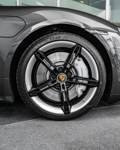 A vertical shot of the front wheel of a Porsche Taycan electric car