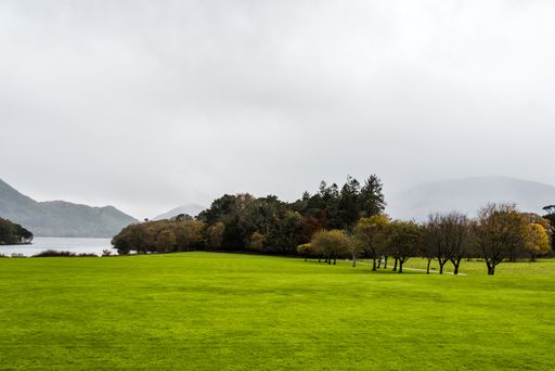 Green gardens of Muckross House in Killarney against a cloudy sky