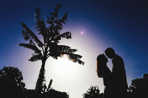 A romantic couple embracing silhouette during a sunset on the beach