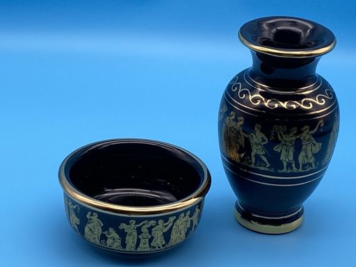 A closeup of a blue decorated vintage ceramic vase and a small bowl isolated on a blue background