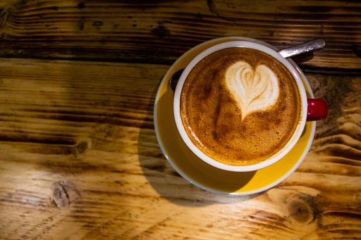 A high angle shot of a delicious latte with a cute heart on a wooden surface