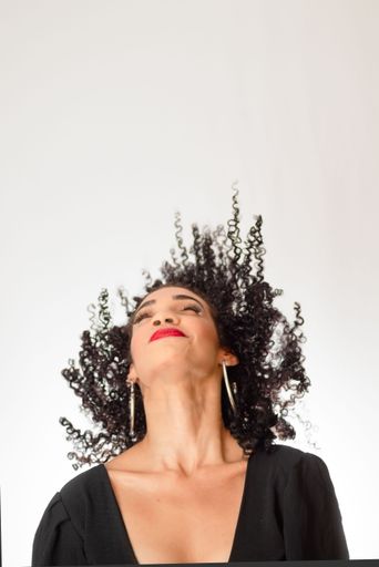 Young smiling woman tossing her hair in the air. Isolated on white background in studio