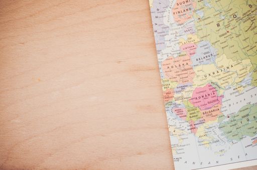 An overhead shot of a geographic map on a wood textured surface with space for your text