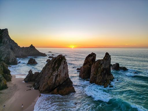 A scenic view of the rock formations in Ursa beach during a beautiful summer day in Portugal