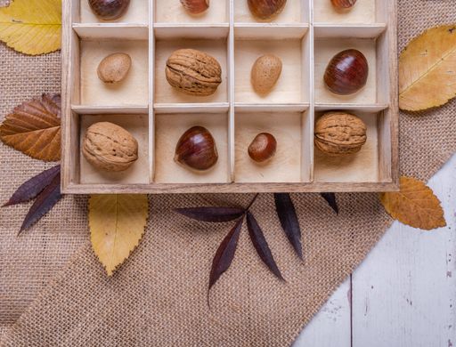 A top view of different kinds of nuts in a wooden box