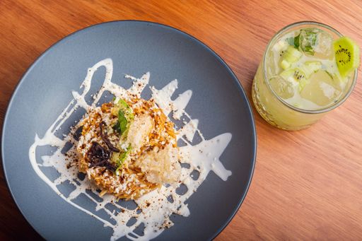a top view of a dish on a gray plate with kiwi cocktail on a wooden table