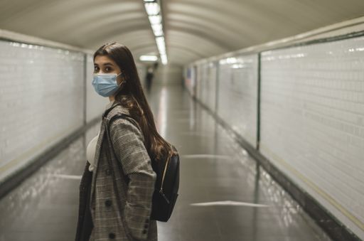 A young Caucasian woman wearing a face mask in a subway tunnel - new normal concept