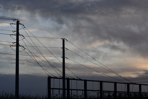 A rainy cloudscape over utility poles with messy electrical cables