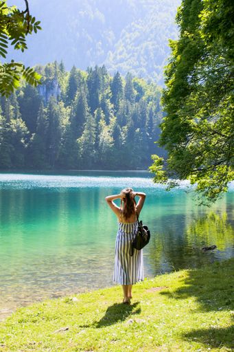 A young Caucasian female in a nice dress posing with the beautiful seascape in the background