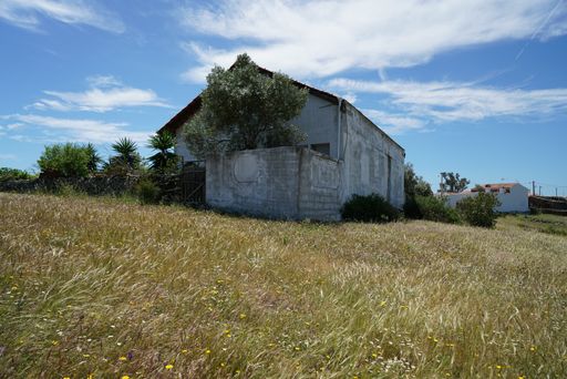 A beautiful cloudscape over a stone-made rural house in a field
