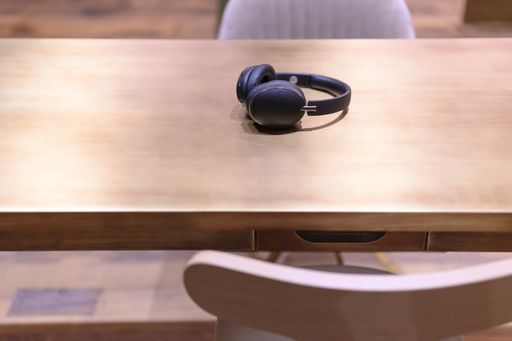 A selective focus shot of a black headphone on a wooden table