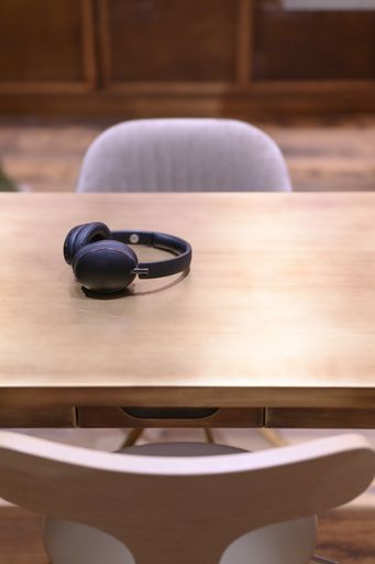 A selective focus shot of a black headphone on a wooden table