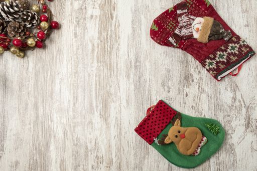 A flat lay of colorful Christmas decorations on a wooden table with a copy space