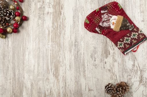 A flat lay of colorful Christmas decorations on a wooden table with a copy space