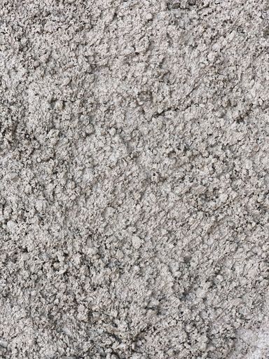 A vertical shot of freshly laid concrete with porous texture at construction site on the sidewalk.