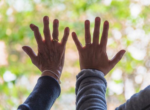 A closeup shot of two people's hands by the glass