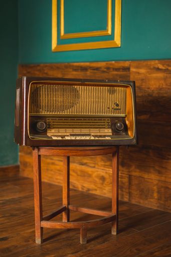 a stylish retro radio player stands on a wooden table. stylish kitchen in the village, daylight from the window.