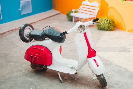 A vintage Vespa scooter parked in front of a home