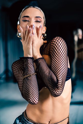 A vertical portrait shot of a sensual Caucasian woman posing in the studio.