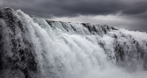 A beautiful shot of beautifully flowing waterfall under the gray cloudy sky