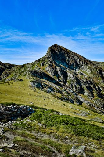 A landscape view in Seven Rila lakes with green fields and mountains, clear sky background