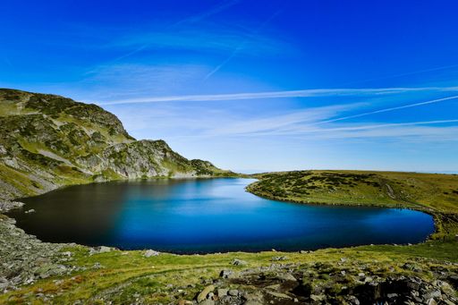 The Seven Rila lakes view with green fields and mountains around, clear sky background