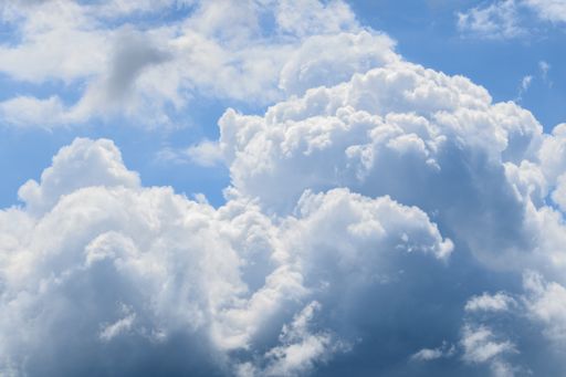 A closeup shot of fluffy white clouds in the beautiful blue sky