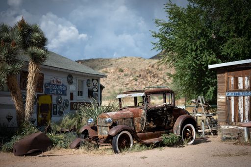 An Old abandoned Ford Model A in a remote town in the park with trees