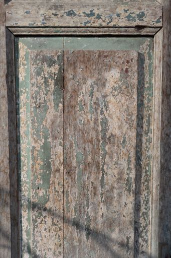 A vertical shot of a weathered wooden door