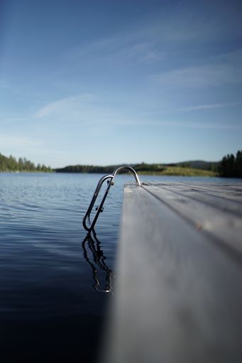 A vertical shot of stairs leading into the lake in the middle of a mountainous scenery