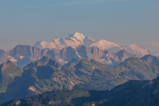 A beautiful landscape of mountains covered in snow on a sunny day with a blue sky in the background