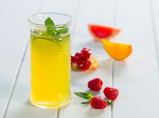 A close-up of fresh lemonade with berries and fruits on the white table