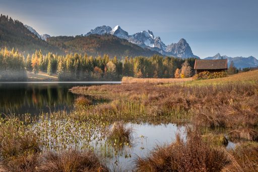 A closeup shot of a small house near the lake in the mountains