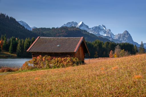 A closeup shot of a small house near the lake in the mountains